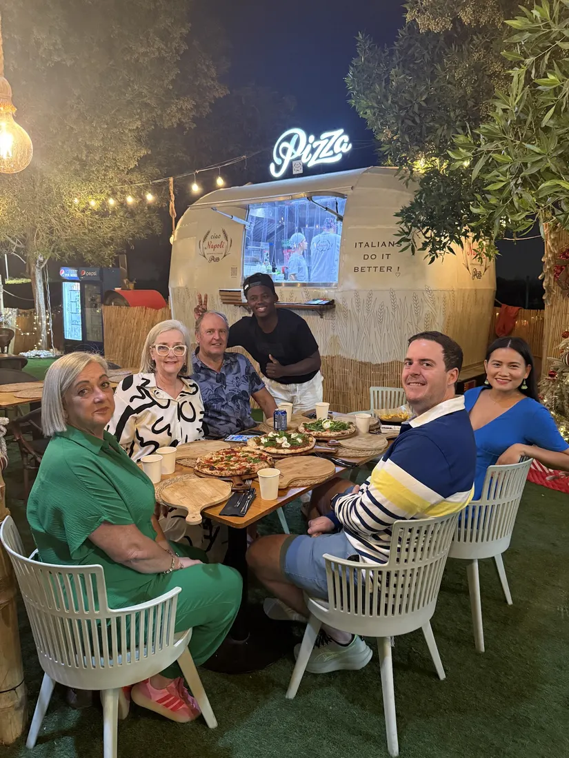 A group of friends smiling at a table by the truck