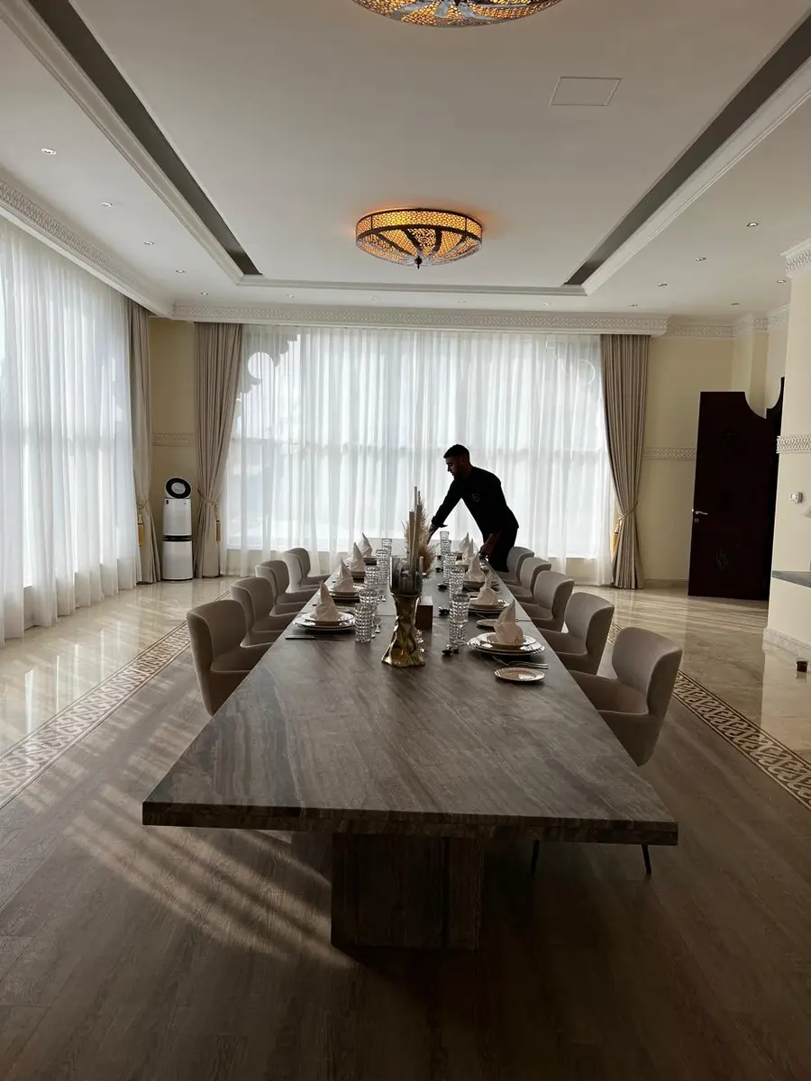 Our team setting a long table for a private dinner in a villa